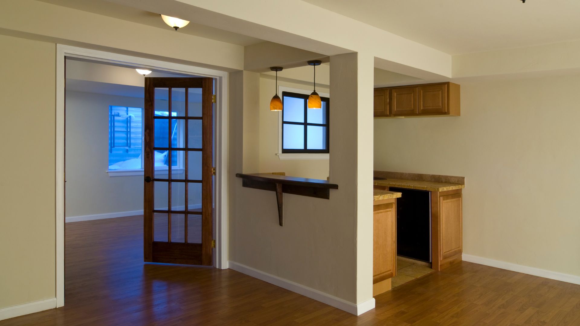 An empty room with a wooden floor and a door