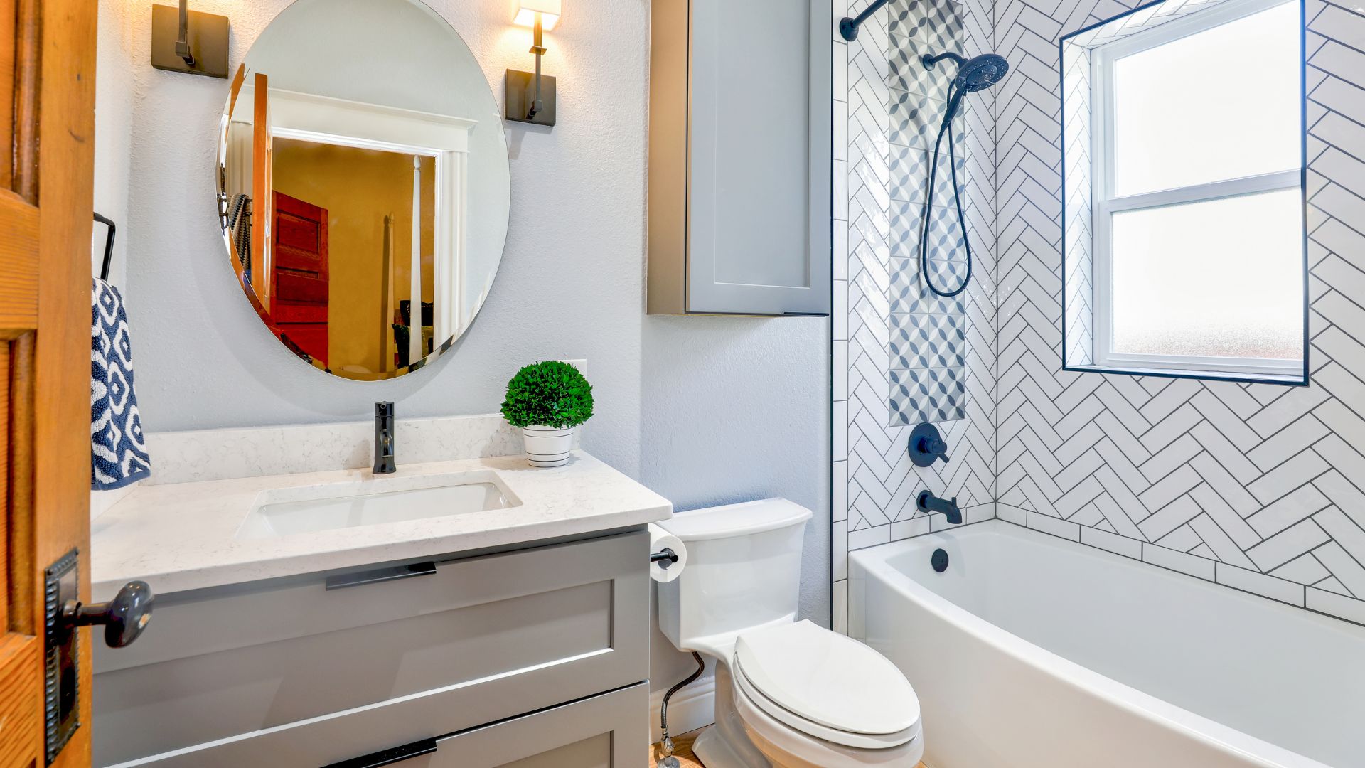 A bathroom with a toilet, sink, mirror and bathtub