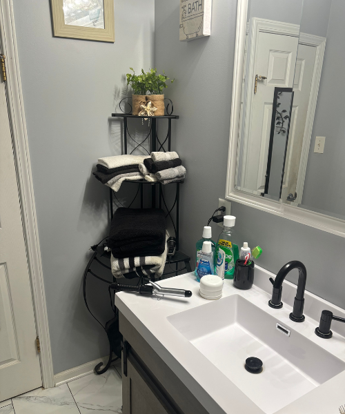 A white sink sitting under a bathroom mirror